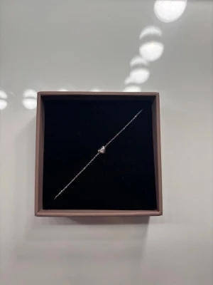 Silverarmband med pärla från Edblad - Helt nytt, aldrig andvänt!Snyggt och stilrent armband i silver från Edblad. Armbandet har en tunn kedja och en litet hjärta i mitten som ger en elegant touch. Perfekt för dig som gillar minimalistiska smycken och vill ha något som passar till många olika looks. 