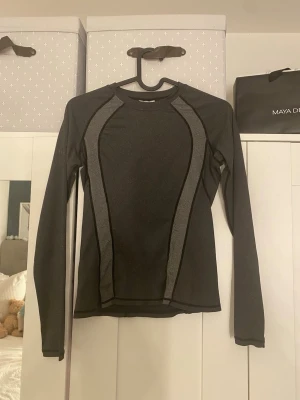 Svart långärmad träningströja MM Sports - Svart och mörkgrå långärmad träningströja från Maya delorez. Tight passform . 🫶🏼 lite ihop sydd på armen som man ser på bild 3😊 storlek xxs 
