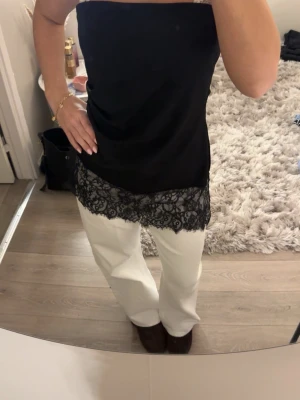 Svart tubtopp med spetsdetalj från Gina tricot  - Säljer en svart tubtopp med snygg spetsdetalj längst ner. Perfekt för trendig layering! Nypris 370kr. Aldrig använd men prislappen är borttagen