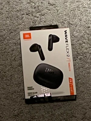JBL Wave Flex 2 True Wireless in-ear - Säljer ett par svarta JBL Wave Flex 2 True Wireless in-ear hörlurar. De har en stilren och kompakt design med laddningsetui i matt plast. Perfekta för musik, samtal och gaming med smart ambient-funktion och kristallklara samtal. Helt nya och helt oanvända! Säljer för 300 kr men kan kan gå med på priser ner till 200 kr möjligtvis!
