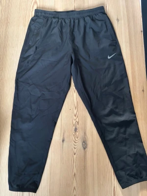 Svarta Nike Dri-FIT träningsbyxor - Svarta träningsbyxor från Nike med Dri-FIT. Perfekta för gymmet eller löprundan. Knappt använda och köptes för 950kr. Storlek M-L