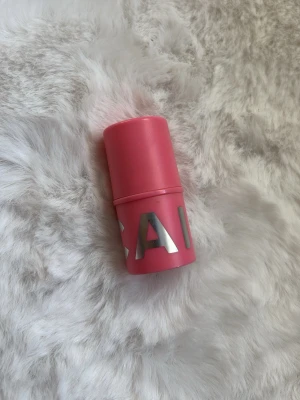 Krämrouge i stick, ljusrosa - Säljer en krämrouge i stickformat med ljusrosa färg. Förpackningen är cylinderformad och rosa med stora silvriga bokstäver. Enkel att applicera direkt på kinderna för en fräsch look. Använd några fåtal gånger.