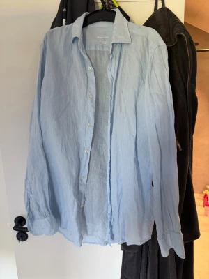 Ljusblå linneskjorta Massimo Dutti - Säljer en ljusblå skjorta från Massimo Dutti i 100% linne. Skjortan har klassisk krage, knappar framtill och långa ärmar med knapp vid manschetten. Perfekt för en avslappnad och stilren look. Köpt i mallorca på Massimo dutti för 900:- aldrig använd! Pågrund av att den passar verkligen M perfekt och inte S