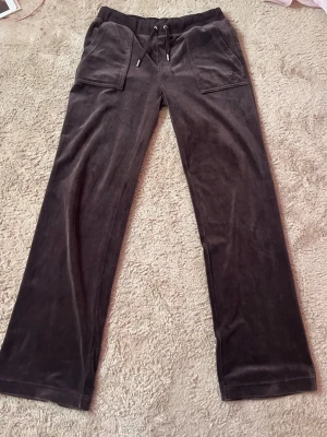 Juicy Couture byxor - Säljer ett par bruna Juicy Couture byxor i storlek s!😍 Har bara använt typ 2 gånger och är nästan som nya!😊 Djur i hus!!!