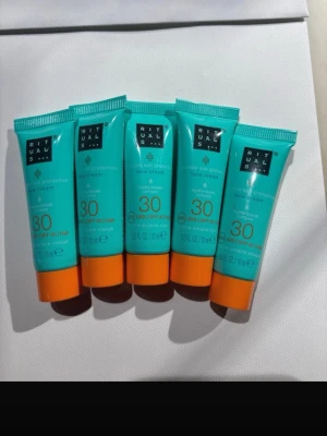 Rituals solskyddskräm SPF 30, 5-pack - Fem tuber ansiktskräm med solskyddsfaktor 30 från Rituals. Tuben är turkos med orange kork och rymmer 10 ml. Perfekt att ha med i väskan för dagligt skydd mot solen. Krämen är anpassad för ansiktet och ger ett högt skydd mot UVA/UVB.
