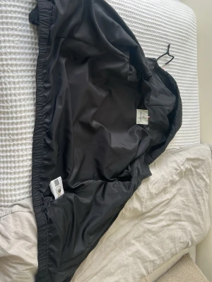 Moncler Jacka - Snygg och stilren Moncler-vindjacka i svart. Jackan är både bekväm och varm, vilket gör den perfekt för blåsiga och kalla dagar. Den har en elegant design som passar till det mesta och är lätt att matcha med olika outfits. Passar bra för personer runt 176–178 cm. Ett perfekt val för dig som vill ha en varm, bekväm och exklusiv jacka med stil.