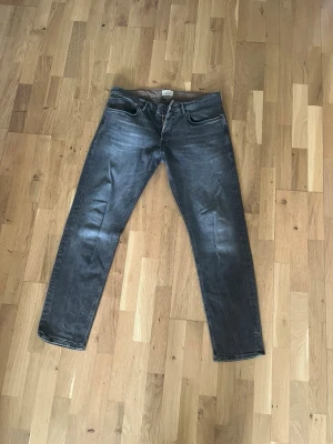 Grå regular jeans från Jack & Jones - Säljer ett par grå jeans från Jack & Jones med klassisk femficksmodell och raka ben. Jeansen har en snygg tvättad look och är tillverkade i ett mjukt denimtyg som passar perfekt till en avslappnad stil.
