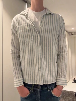 Randig skjorta - Randig linne skjorta ifrån Zara i ett bra skick. Skriv vid minsta lilla intresse. Storleken är 164 men den är stor i storleken, passar dig som brukar bära xs eller s
