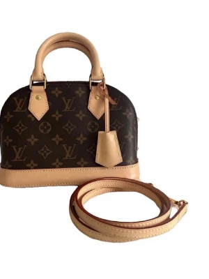 Alma BB Monogram väska - Säljer en  Alma BB handväska i monogram canvas med beige läderdetaljer och guldfärgade metalldelar. Väskan har rundad form, två handtag och avtagbar axelrem. Perfekt för dig som vill ha en ikonisk och trendig accessoar. Super bra kvalitet låda och dustbag medföljer 