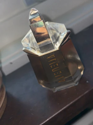 Mugler Alien Goddess EdP 30ml - Helt ny Alien Goddess Eau de Parfum från Mugler i 30 ml flaska. Doftar varm vanilj men mer elegant och kvinnligt. Parfymen kommer i en lyxig, guldskimrande glasflaska med geometrisk design. Doftar varm vanilj men mer elegant och kvinnligt. Helt ny