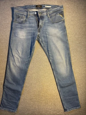 Replay Jeans Slim - Replay Jeans Anbass slim fit. Helt nya köpta på jeans bolaget. Aldrig använda endast testade 1 gång. Kvitto finns om man vill se. Säljer så billigt då min son växte ut dem innan han kunde använda dem. Köpta för 1200kr på jeans bolaget. Storlek 34 i midjan och 32 i längden.