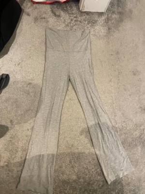 Grå leggings yoga pants från Gina Tricot - Säljer ett par grå leggings från Gina Tricot i mjukt och stretchigt material. De har hög midja och utsvängda ben, perfekta för en avslappnad och trendig look. Passar dig som gillar bekväma och stilrena plagg.