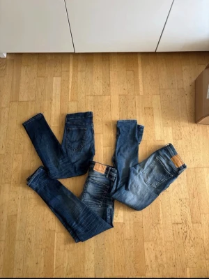 Jack&jones jeans bulk  - Säljer flera par blå jeans i olika tvättar, från mörkblå till ljusare blå. Alla har klassisk femficksdesign och tydliga slitningar för en trendig, använd look. Perfekta för dig som gillar en avslappnad och modern stil. Storlek varier från 30x30-28x32-32x34