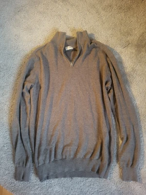 Ljusbrun halvzip john henric - Säljer en ljusbrun halvzip från John Henric med half zip och hög krage. Tröjan har lång ärm och ribbade muddar vid ärmslut och nederkant. Perfekt för dig som gillar stilrena och mjuka plagg. Den är i 100% bomull