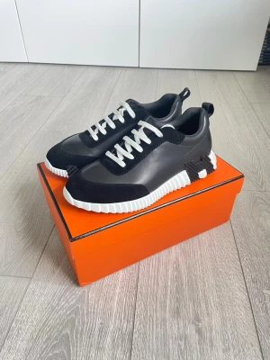 Svarta H sneakers - Säljer ett par svarta H-sneakers i nyskick.  En tidlös och stilren modell som fungerar lika bra till jeans och t-shirt som till chinos eller mer uppklädda outfits. Perfekta för dig som vill ha en lyxig sneaker med hög komfort och exklusiv känsla. Svarta skosnören medföljer.