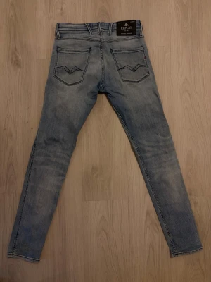 Replay Jeans - Säljer ett par ljusblå jeans från Replay. Modellen heter Anbass och är deras slimade version. Jeansen har en klassisk femficksdesign och snygga kontrastsömmar. Jeansen har en slimad passform och är tillverkade i mjukt denimtyg. Perfekta för en avslappnad och trendig look. Storlek: 29/32.
