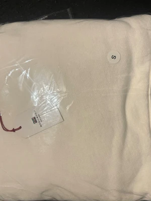Vit hoodie i storlek S - Säljer en stilren vit hoodie i storlek S. Hoodien har en klassisk design med huva och är tillverkad i mjukt material som känns skönt mot huden. Perfekt för dig som gillar en clean och enkel look.