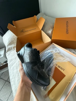 Svarta sneakers - Snygga svarta sneakers från i läder med präglade monogramdetaljer på sidorna. Skorna har en klassisk låg siluett, svarta skosnören och en robust sula. Perfekta för dig som vill ha en exklusiv och stilren look.