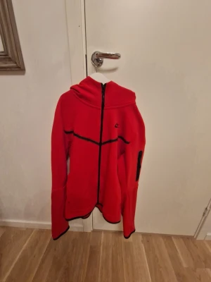 Röd Nike Hoodie - Nike hoodie/jacka i röd färg med svart detaljer och dragkedja. Snygg och stilren modell med Nike-logga på bröstet. Perfekt till vardags, träning eller streetwear. 🟥🖤 Bra skick – se bilder för skick och detaljer. 