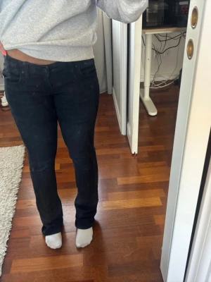 Mörkblå raka jeans - Säljer ett par mörkblå jeans med rak passform och klassisk femficksdesign. Jeansen har normal midja och är tillverkade i ett stretchigt denimtyg som sitter bekvämt. Perfekta till vardagslooken och lätta att matcha med olika stilar. I stolek w26 l32