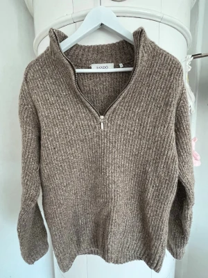 Beige stickad tröja med halvzip Sandö - Mysig beige stickad tröja från Sandö med halvzip och hög krage. Tröjan har ribbstickad struktur och långa ärmar. Bra skick knappt använd, storlek s. Kolla även mina andra annonser för paketpris