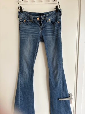 Blå low rise flare jeans Joey - Säljer ett par blå jeans från True Religion, modell Joey Low Rise Flare. Jag köpte jeansen för 1300kr och nu säljer jag de för 800kr då de är k nyskick
