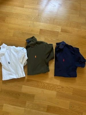 3 klassiska pikétröjor från Polo Ralph Lauren - Säljer tre pikétröjor från Polo Ralph Lauren i vitt, mörkgrönt och marinblått. 300kr/st eller alla tre för 700kr!. Alla är i storleken L (14-16)