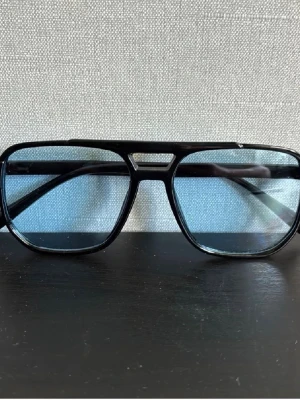 Svarta pilotbågar med blåtonade glas - Snygga solglasögon med klassisk pilotform och svarta bågar i plast. Glasen är gröntonade och ger en cool retrovibe. Perfekta för dig som vill sticka ut med en stilren accessoar till sommaren. Hör av dig vid minsta fundering!🤩💯 diskutera pris vid snabb och enkel affär👑👑