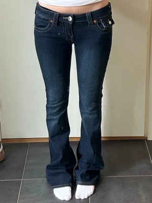 Mörkblå bootcut jeans med låg midja - Säljer ett par mörkblå bootcut jeans med låg midja från true religion i storlek 24. 