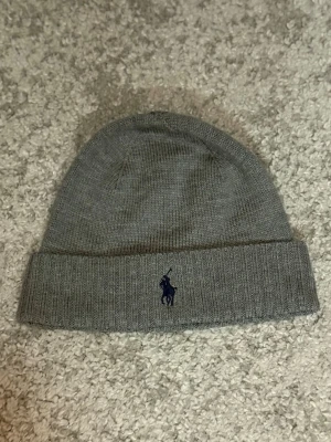 Polo Ralph Lauren Merino Ullmössa  - Polo Ralph Lauren mössa i merinoull med stilren och klassisk design. Varm och passar perfekt under höst och vinter.  Färg: Marinblå Storlek: NO SIZE  Fraktar inom 24h vid snabb affär. Byten är inte aktuella.  #PoloRalphLauren #RalphLauren #Mössa #MerinoWool #Menswear