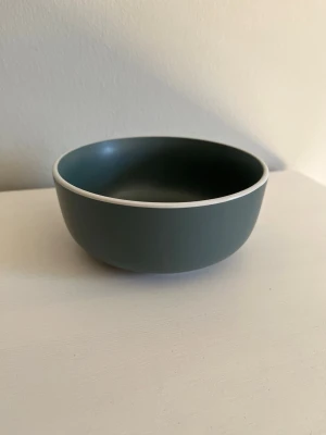 Mörkgrön skål från Day Useful Everyday - Fin skål från Day Useful Everyday i en mörkgrön färg med vit kant! Diameter: ca 14,5 cm. Säljs i mycket bra skick! Kika gärna in på mina andra annonser och hör gärna av dig vid frågor och intresse!