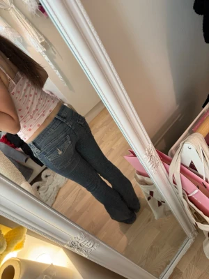 Blå bootcut jeans låg midja - Säljer ett par klassiska blå jeans med bootcut och låg midja. Jeansen har fem fickor, snygga sömmar och är i ett mjukt denimtyg som sitter skönt på kroppen. Perfekta för dig som gillar en avslappnad men trendig look.