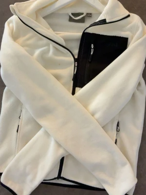 Vit fleecejacka med svart ficka - vit fleece med en svart ficka perfekt nu till hösten 