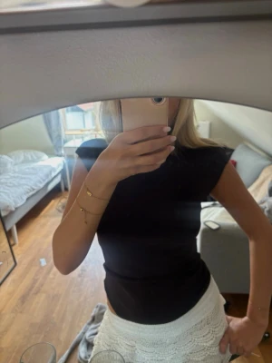Svart ärmlös topp med tight passform - Säljer en svart, ärmlös topp med tight passform och rund hals. Enkel och stilren design som passar perfekt till både jeans och kjol. Toppen är gjord i ett mjukt material och har en klassisk look.