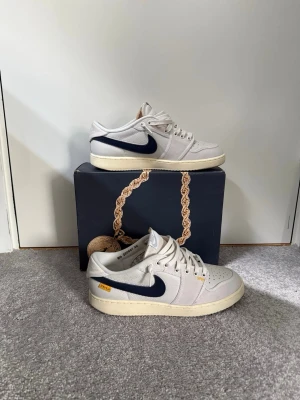 Jordan 1 retro AJKO low sp UNION - Union jordan 1 AJKO köpta på flightclub 2023. Stilrena skor som man inte ser jätteofta. De är använda men fortfarande i väldigt fint skick. Stickers, swoosh och laces ingår självklart.