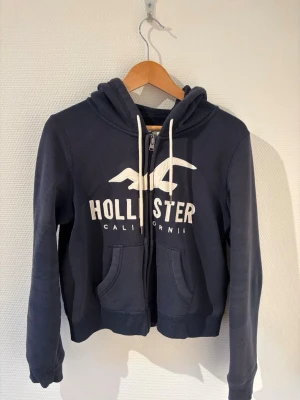 Hollister Zip-hoodie med luva  - Mörkblå zip-hoodie med luva från Hollister💙.           Storlek M