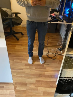 Blå slim fit jeans herr - Säljer ett par klassiska blå slim fit jeans med normal midja och raka ben. Jeansen har fem fickor och stängs med dragkedja och knapp. Perfekta för en avslappnad och stilren look. Materialet är denim i bomull. 30/32 