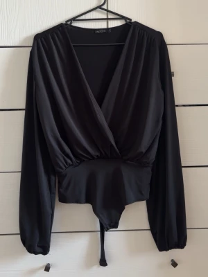 Svart body - Svart body med omlottdesign