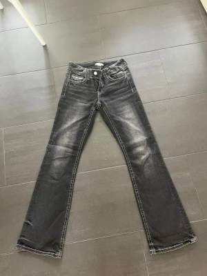 Svarta bootcut jeans från Gina Tricot - Säljer ett par svarta bootcut jeans med snygga slitningar och ljusa tvättade partier framtill och baktill. Går att spänna till tajtare och lösare i midjan!                                                                       Bra skick, djur och rökfritt hem 💕