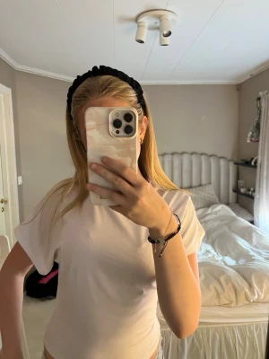Figursydd T-shirt med utsvängda ärmar - En enkel och stilren vit t-shirt med rund hals och korta ärmar. T-shirten har en normal passform och är tillverkad i mjuk bomull, perfekt för en clean och avslappnad look.