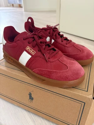 Röda Polo Ralph Lauren sneakers - Snygga sneakers i rött från Polo Ralph Lauren. Säljs då dom ibte har använts.