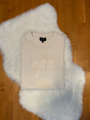 Vit t-shirt från A.P.C. med broderi - Snygg vit t-shirt från A.P.C. med broderad text 'apc ' på bröstet. Klassisk passform med korta ärmar och rund halsringning. Tillverkad i mjuk bomull som känns skön mot huden. Tröjan är i otroligt fint skick, inga tecken på användning. Hör av er med frågor och funderingar! 🙏
