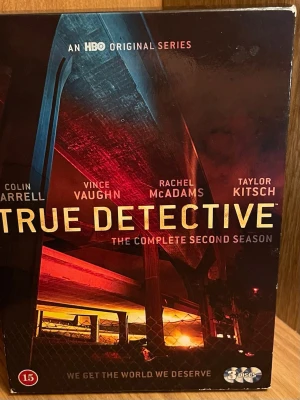 True Detective Säsong 2 DVD-box - True Detective: The Complete Second Season på DVD. Innehåller 3 skivor med hela säsongen och extramaterial. Omslaget har mörka och röda toner med motiv från serien. Perfekt för dig som gillar kriminaldrama och spännande berättelser. Perfekt Skick