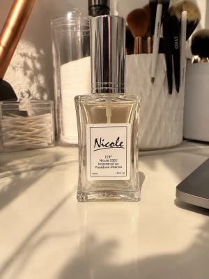 Nicole EDP Parfym 30 ml - En elegant parfym från Nicole, EDP 2062 inspirerad av Paradox Intense. Flaskan är genomskinlig med en stilren, fyrkantig form och har ett silverfärgat lock. Innehåller 30 ml doft. Perfekt för dig som gillar exklusiva och moderna dofter.