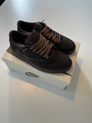 Travis Scott x Air Jordan 1 Low “Velvet Brown” - Sällsynt Travis Scott x Nike Air Jordan 1 i brunt/mockafärgat sammet. Ikonisk colorway med Cactus Jack-branding, mycket eftertraktad bland sneakerheads.   Skick: Nytt Skick Storlek: 42 (EU) Skickas snabbt och säkert! 📦