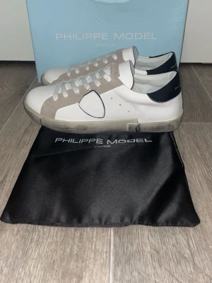 Philippe Model vita och grå sneakers - Snygga vita sneakers från Philippe model, helt oanvända, skickas samma dag vid köp! (Inget kvitto då jag fick dom av min farfar) Om det är något ni undrar över så är det bara att fråga 