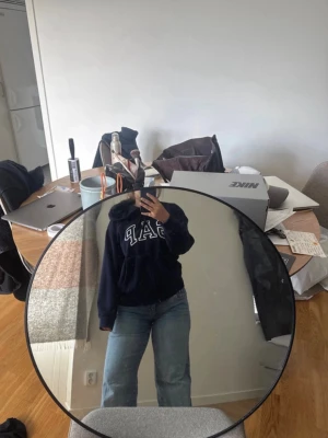 Mörkblå hoodie från GAP - Säljer en mörkblå hoodie från GAP med stor vit logga på bröstet. Den är lite oversized i storlek M! 