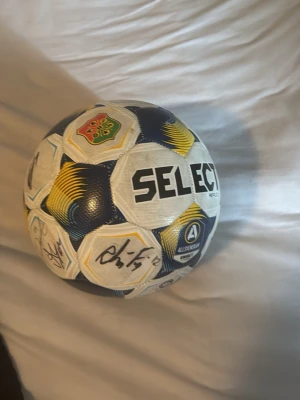 Select fotboll med autografer - Säljer en fotboll från Select med tryck i vitt, blått och gult samt flera autografer. Bollen har Allsvenskan-logga och klubbmärke. Perfekt för dig som samlar på fotbollar eller gillar svensk fotboll.