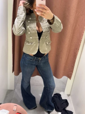 Tunn jacka från Gina Tricot  - Snygg  grön tunn jacka från Gina Tricot med militärinspirerade detaljer och dekorativa knappar framtill. Modellen är kortare och har två fickor framtill köpt för 699kr använd 2 gånger 