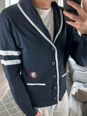 Cardigan Mörkblå Unik  - Väldigt, väldigt snygg och lite unik cardigan. Mått: A:50 B:47 C:44 D:66 (cm) Skriv vid fundering 😇🙌